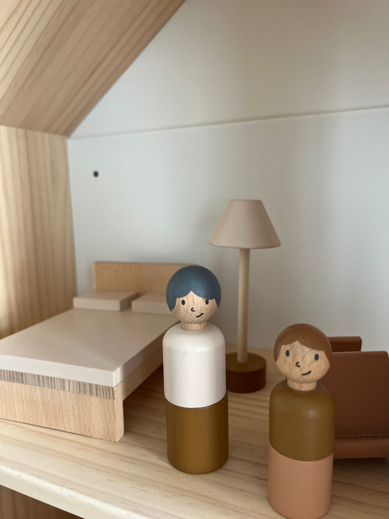 Puppenhaus-Zimmer mit Bett, Lampe und zwei Holzfiguren