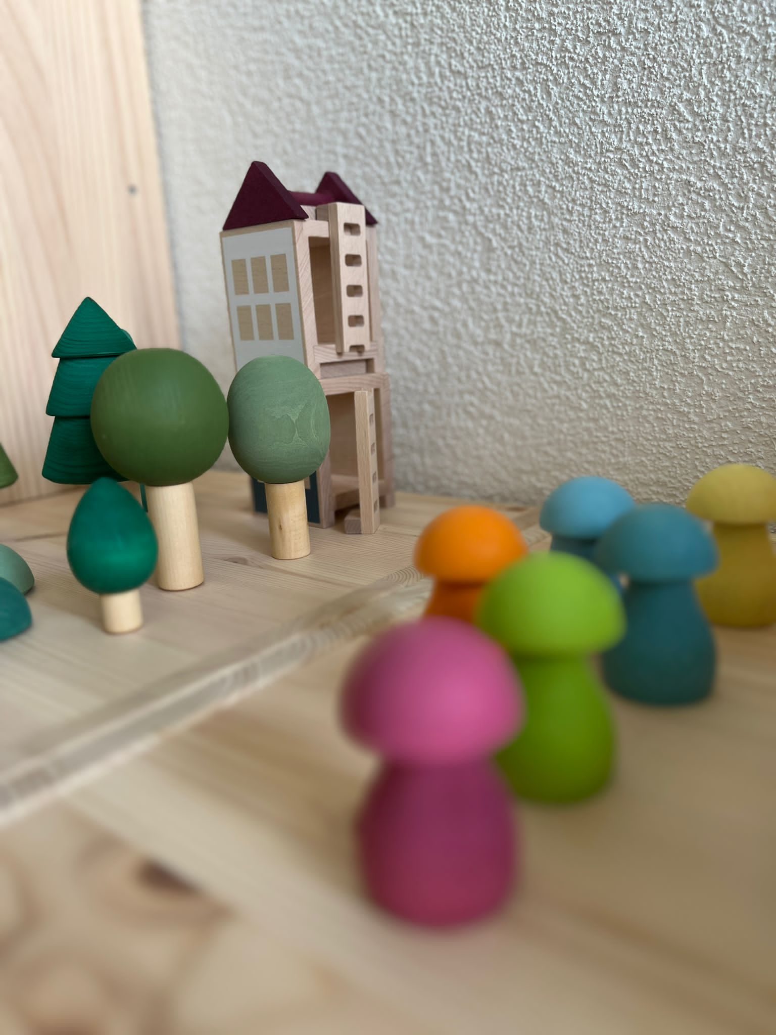 Holzbäume, Holzhäuser und bunte Holzpilze auf einem Tisch